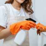 close-up-hand-young-housekeeper-woman-rubber-gloves-use-cleaning-solution-spray-bottle-white-furniture-use-cloth-clean-it-min