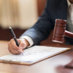 The lawyer is carrying a pen to write a case record in the courtroom