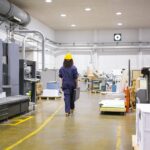 african-american-female-industrial-employee-hardhat-overall-walking-plant-floor-min